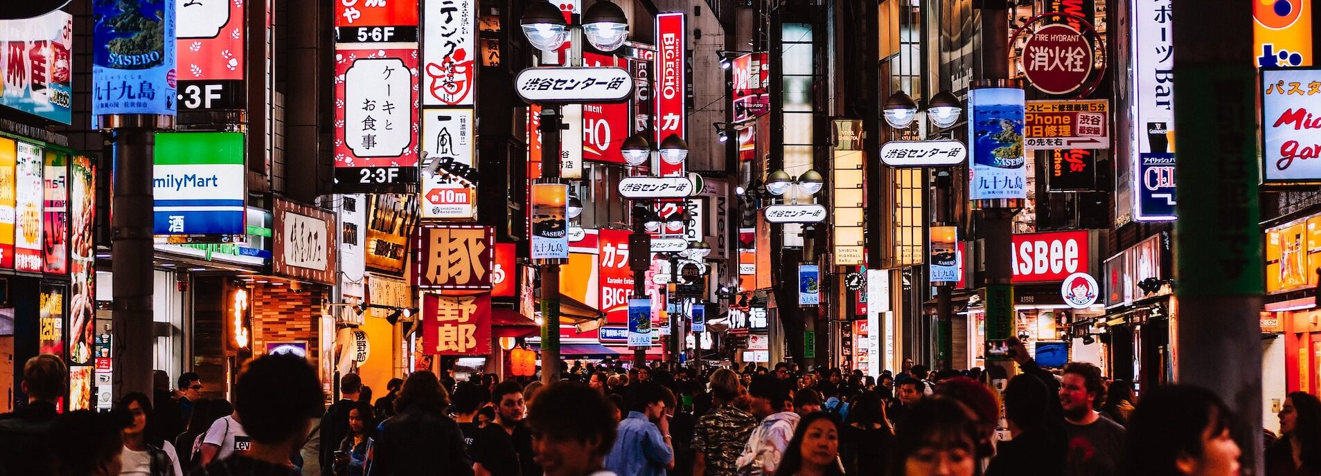 Night shot of a crowded street in Tokyo full of neon signs.